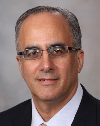 Portrait of a researcher with glasses and a suit.